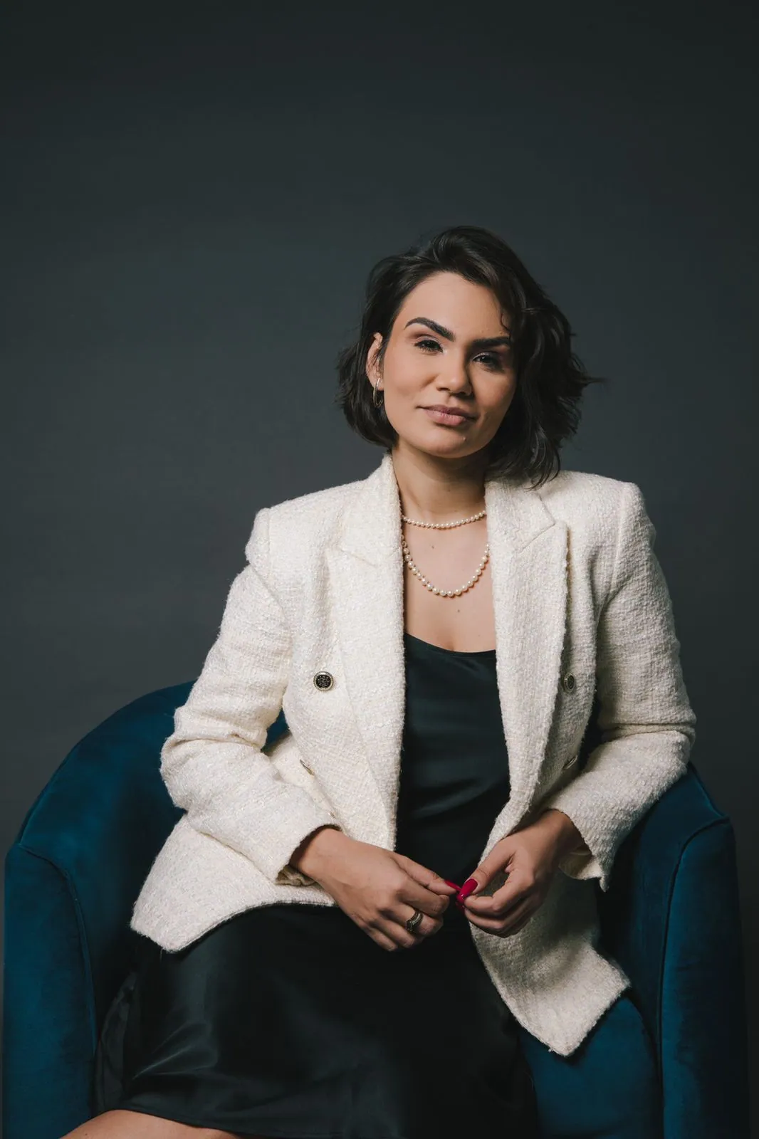 Bárbara Massoni sentada em uma poltrona, em retrato de estúdio